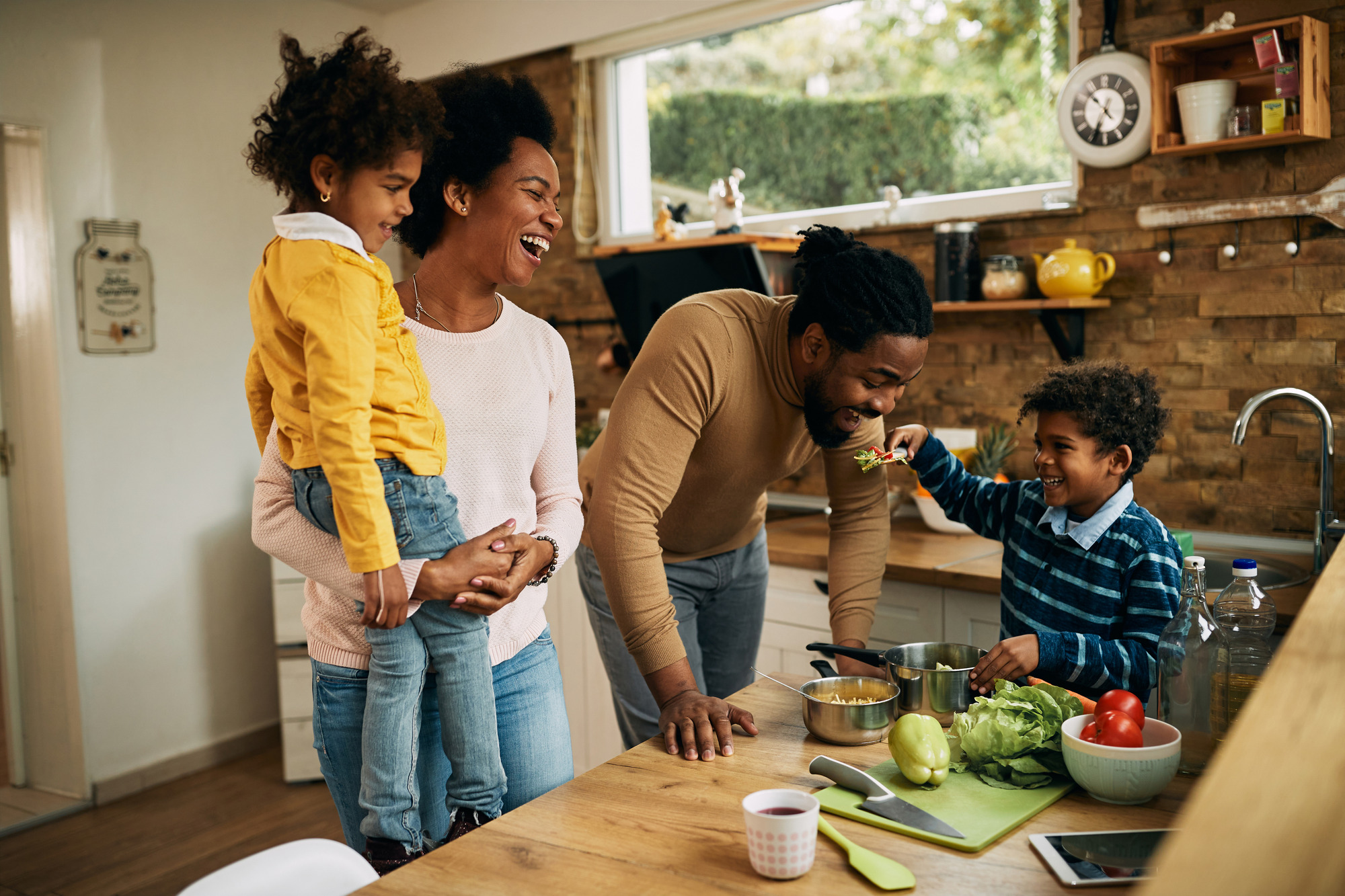 A cheerful family preparing healthy food together in the kitchen.